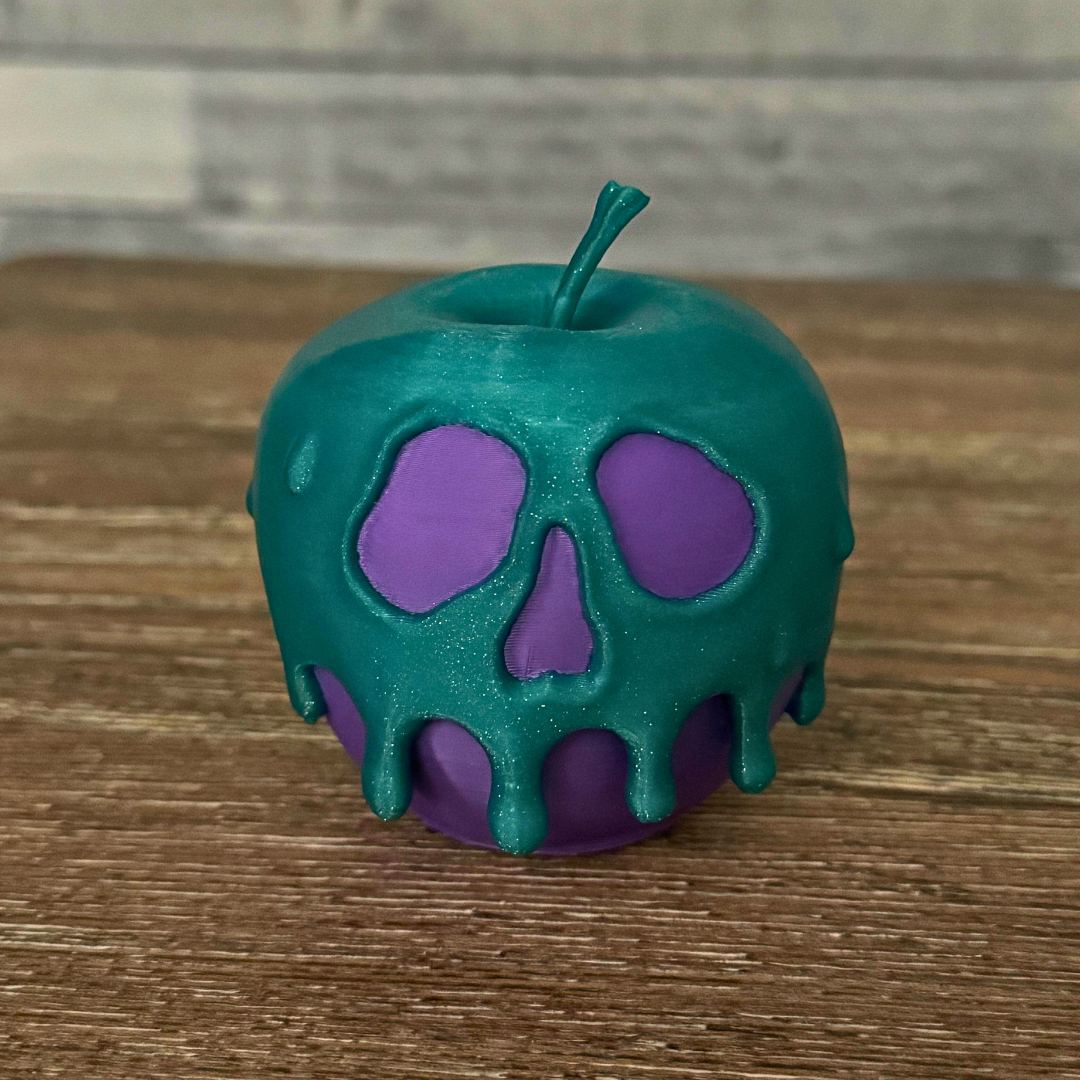 A purple and teal poison candy apple on a wooden table, ideal for Halloween decor.